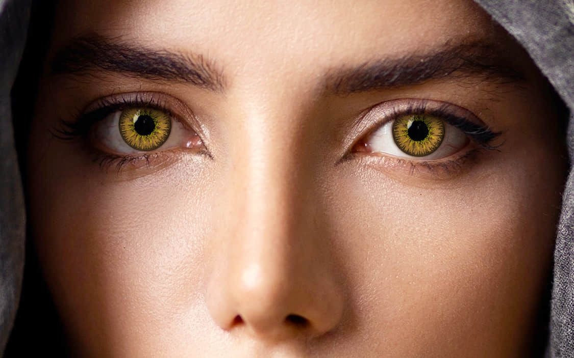 close-up of both eyes wearing amber colored contact lenses