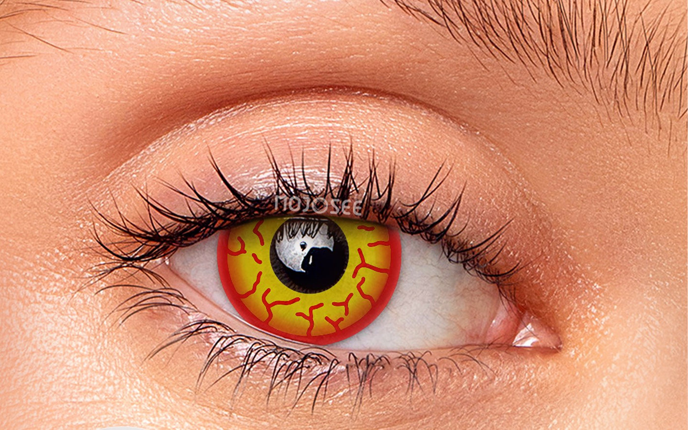 Yellow and red villain-style lens on an open eye