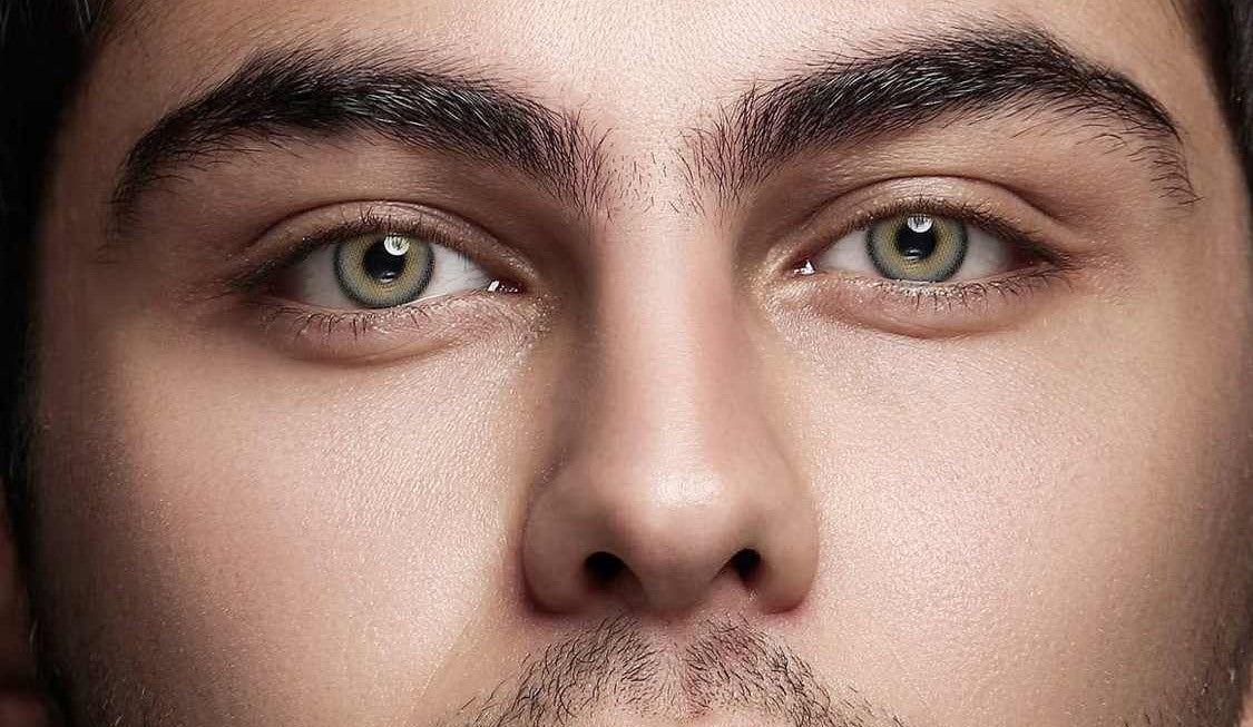 Horizontal close-up of a male model wearing gray colored contact lenses