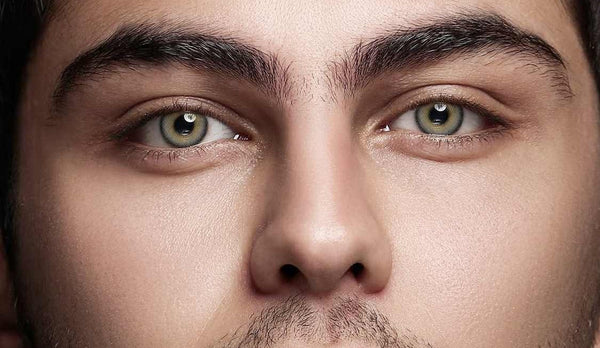 Horizontal close-up of a male model wearing gray colored contact lenses