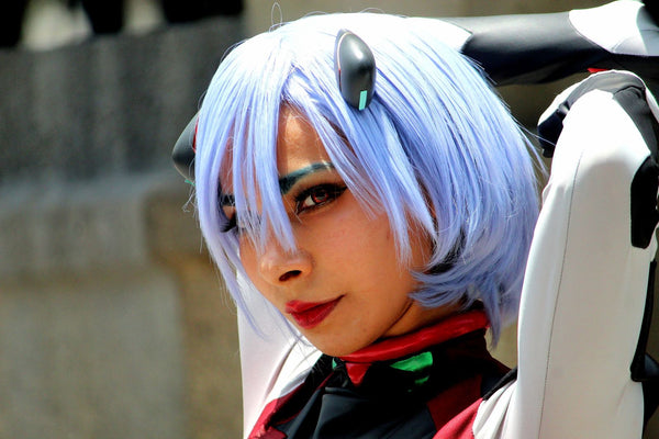 Cosplayer with a blue wig and enlarged doll-like eyes