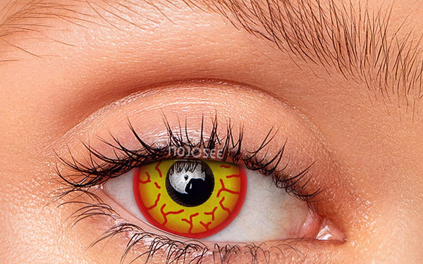 Yellow-and-red villain lens worn on an open eye