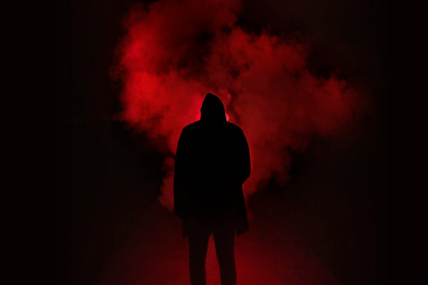 Dark hooded silhouette in red smoke, moody cosplay atmosphere