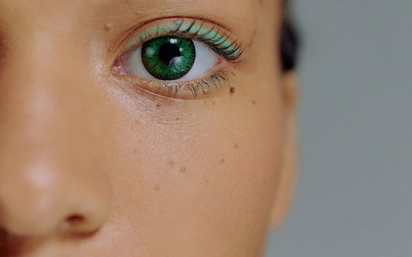 Close-up of an eye wearing a vivid green colored contact lens