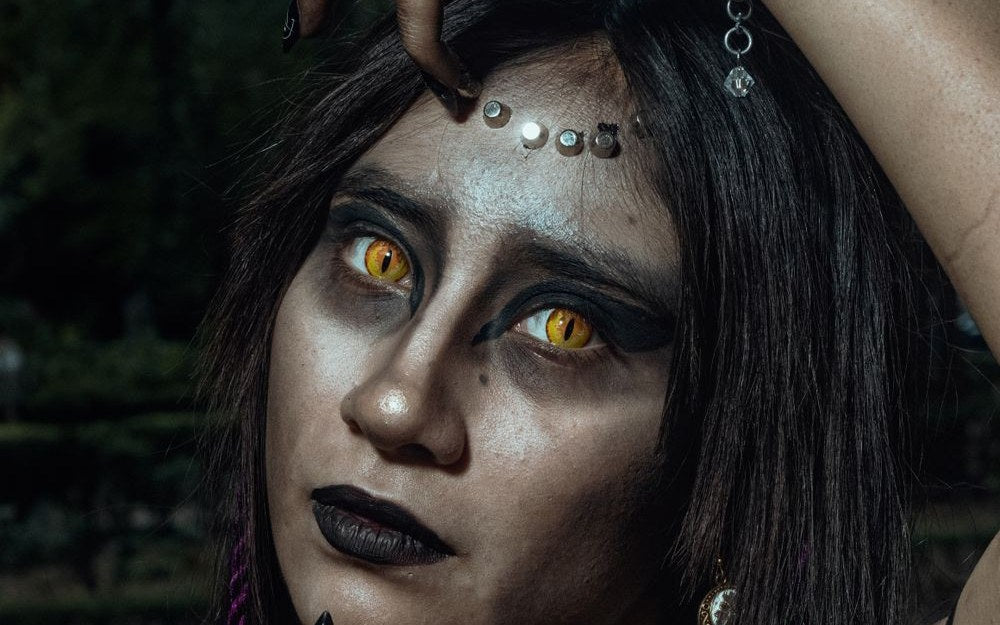 Fantasy party look with striking yellow colored contacts and dark makeup