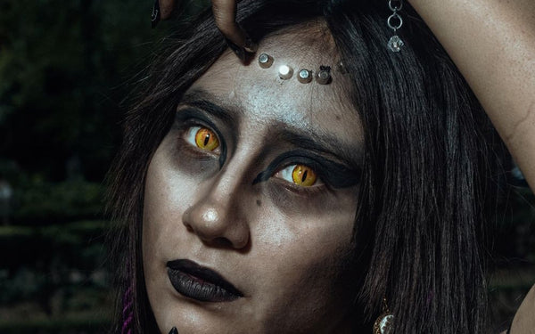 Fantasy party look with striking yellow colored contacts and dark makeup