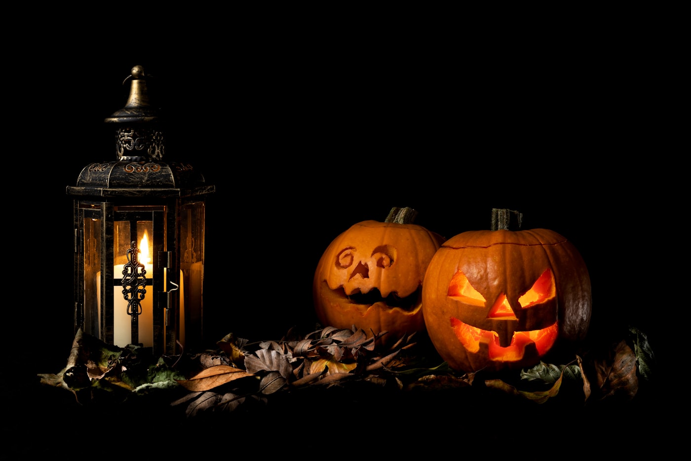 carved jack-o-lanterns and a lantern glowing in the dark