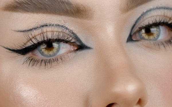 close-up of eyes wearing gray colored contact lenses with graphic eyeliner