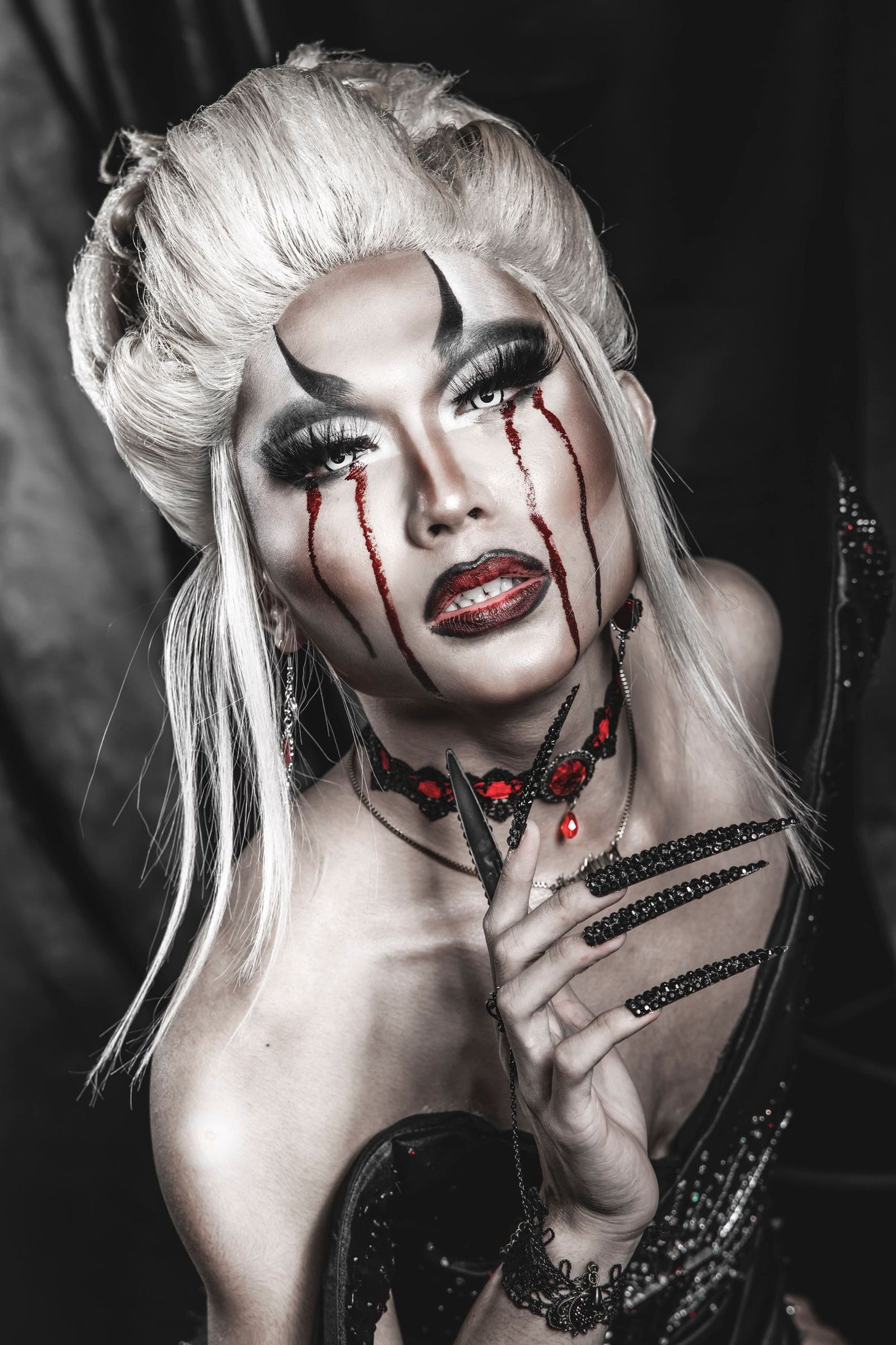 Gothic vampire portrait with blood-tear makeup and dark elegance