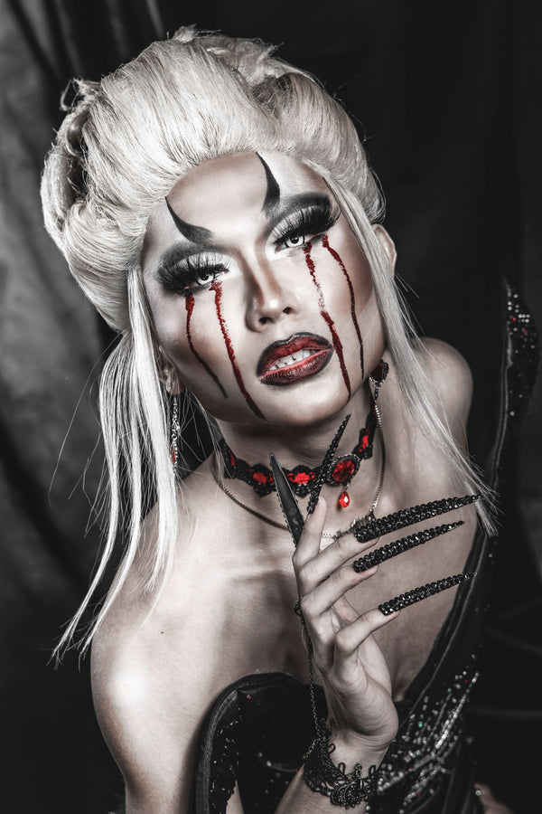 Gothic vampire portrait with blood-tear makeup and dark elegance