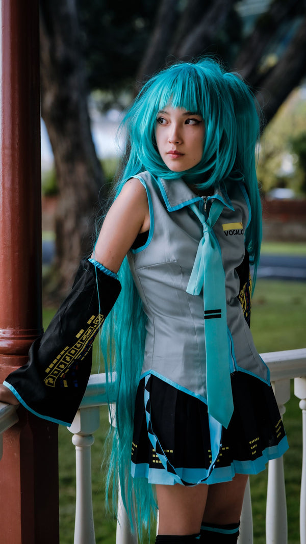 Cosplayer with teal wig photographed in soft outdoor light
