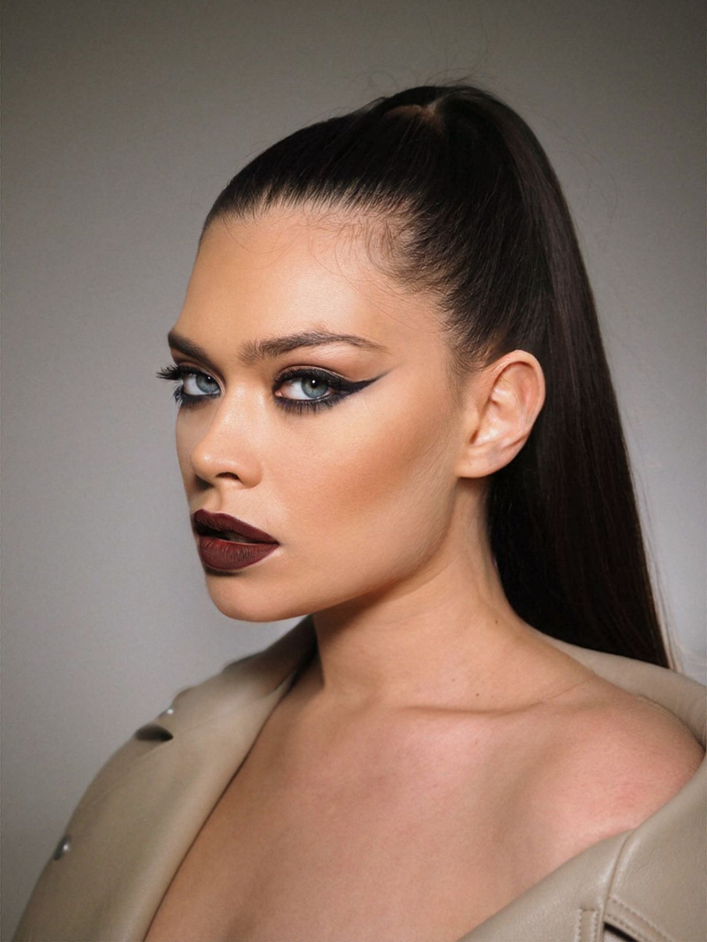 Studio portrait with sharp winged eyeliner and sleek ponytail — the classic cat-eye finish