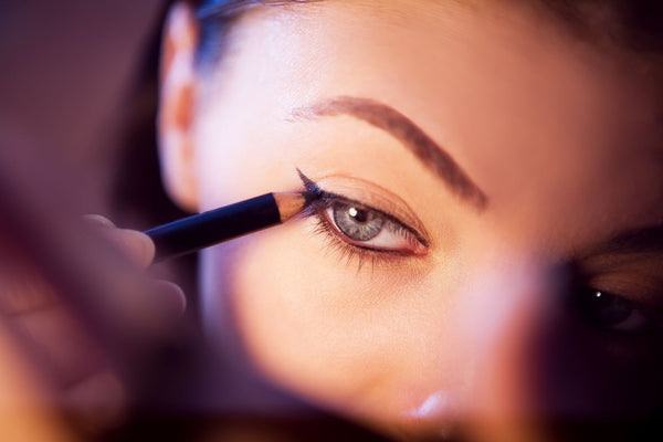 Close-up of a woman applying eyeliner with precision